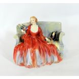 A Royal Doulton porcelain figure 'Sweet and Twenty', of a lady seated on a sofa in formal dress,