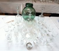 A large green glass carboy, 32cm high, three matching decanters, a cut glass fruit bowl,