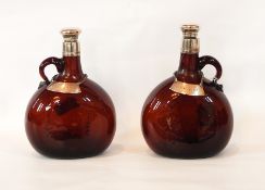 A pair of amber glass wine flasks, silver mounted with silver mounted stoppers,