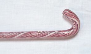 A glass walking cane with two twist coloured inclusions in pink and white,