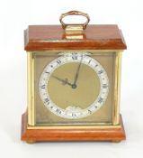 A mahogany cased mantel clock with carrying handle, silvered chapter ring with Roman numerals,