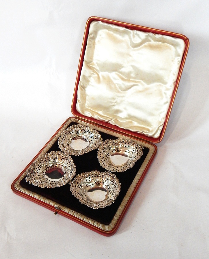 A set of four Victorian silver heart-shaped bonbon dishes with C-scroll floral borders and open