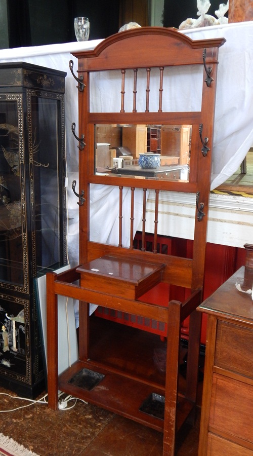 An Edwardian mahogany hall stand, with mirror back and spindle supports, scroll brass hangers,