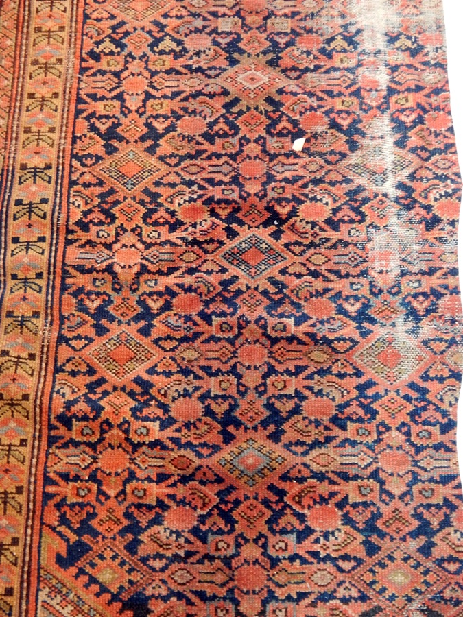 A Persian style rug with blue ground, geometric pattern, cream guard fences and red border,