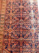 A Persian style rug with blue ground, geometric pattern, cream guard fences and red border,