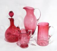 Cranberry glass jug, slender ovoid, with clear handle and foot,