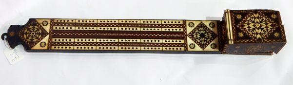 An old ivory and ebony inlaid cribbage board with box containing pegs to base