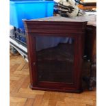 A 19th century mahogany corner cupboard, the glazed panel door enclosing shelf,