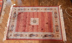 A Persian style prayer mat with red ground, geometric decoration,