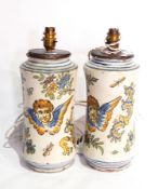 A pair of continental maiolica table lamps of waisted form, depicting cherubs and flowers,