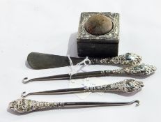 Three silver-handled button hooks,