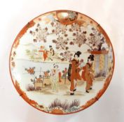 A Japanese Kutani charger depicting woman and child in garden with lake and further figures in