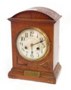 Early 20th century oak dome top mantel clock with silvered dial and brass presentation plate below,