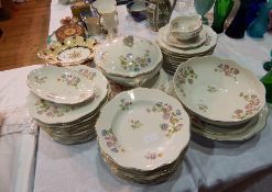 A Limoges part dinner service comprising dinner plates, bowls, serving dishes, a covered tureen,