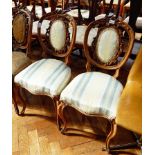 A set of three Victorian carved walnut dining chairs with upholstered panelled backs,