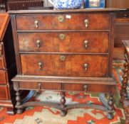 An 18th century oak and walnut chest on stand with moulded edge top, three long graduated drawers,