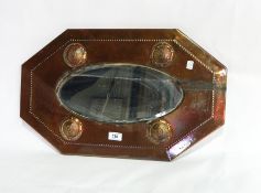 A copper octagonal framed wall mirror with oval plate and raised roundel decoration with bead