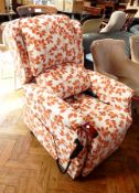 An electric reclining chair with white ground and covered with orange floral fabric