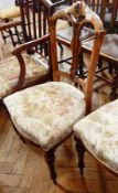 A pair of oak chairs with geometric splat, rose decoration, with floral fabric seats,
