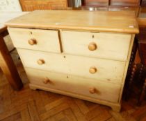 A pine chest of two short and two long drawers, on figured supports,