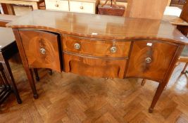 A serpentine fronted mahogany sideboard with two flanking cupboards and drawer,