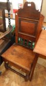 An 18th century oak lambing chair, with shaped crest rail, panelled back,