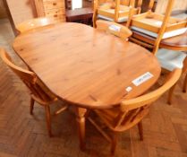 A pine kitchen table together with four matching chairs