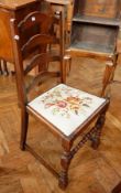 Three ladderback chairs with fabric cushions with floral decoration, on bobbin and block supports,