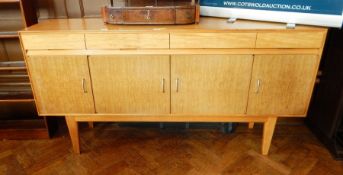 Gordon Russell sideboard with four short drawers and four under-cupboards, on tapering legs,