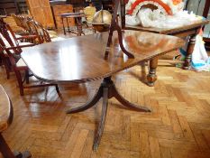 A modern D-end extending dining table on pedestal supports and splayed legs,