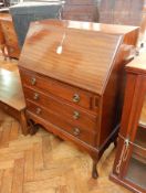 A mahogany bureau with fitted interior, with three long drawers below,