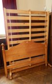 A modern pine bedstead with carved head and tail boards and slatted base,