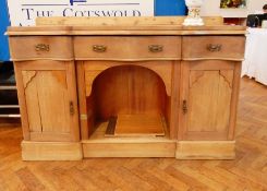 A Victorian pine sideboard with serpentine front, three frieze drawers, open shelf below,