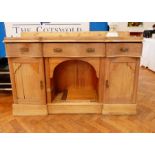 A Victorian pine sideboard with serpentine front, three frieze drawers, open shelf below,