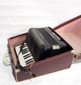 A piano accordion, three framed pictures, cigarette cards of trains,