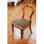 A pair of Victorian mahogany balloon back dining chairs, with carved scrollwork supports,