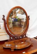 A Victorian mahogany oval swing frame dressing table mirror on carved supports,