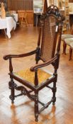 A pair of 17th century style oak high back armchairs, with carved crest rails, cane panel backs,