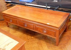 An Eastern rectangular top hardwood coffee table with three frieze drawers,