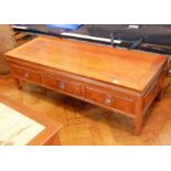 An Eastern rectangular top hardwood coffee table with three frieze drawers,