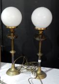 A pair of brass standard lamps with oval smoky glass shades