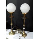 A pair of brass standard lamps with oval smoky glass shades