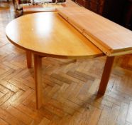 A circular pine dining table with two extra leaves,