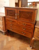 A mahogany veneered drinks cabinet with stringing and marquetry decoration,