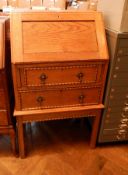An oak bureau with two long graduating drawers, beaded decoration and borders,