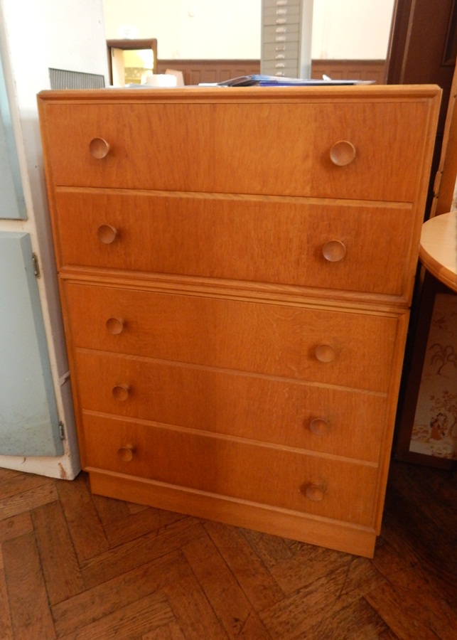 A pine chest of five drawers with circular handles,
