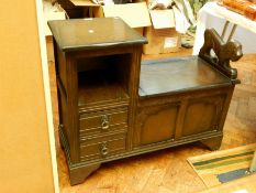 A stained oak telephone table with carved lion arm rest and fitted two drawers,