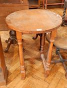 An oak circular topped side table on tapered legs, block and bun feet,