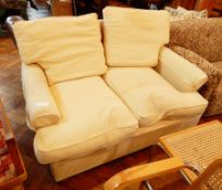 Two seater sofa, with loose cushions back and seat, in pale yellow upholstery,