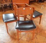 A set of four contemporary dining chairs, with padded seats on square tapering legs,